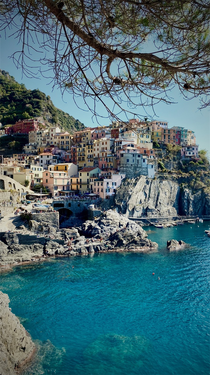 Colourful cliffside houses above a turquoise cove